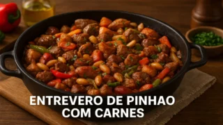 Entrevero de pinhão com carnes servido em panela de ferro com legumes coloridos.
